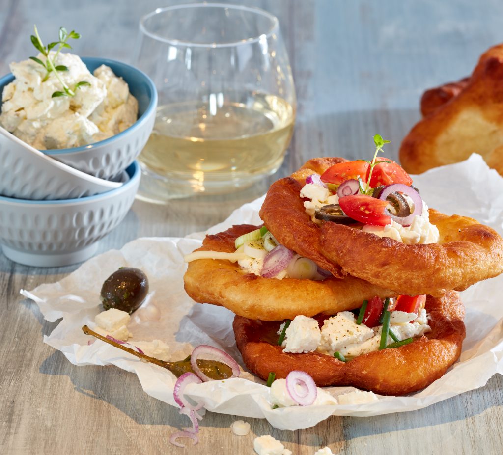 Culinaria Langos, angerichtet mit Feta, Tomaten, Oliven