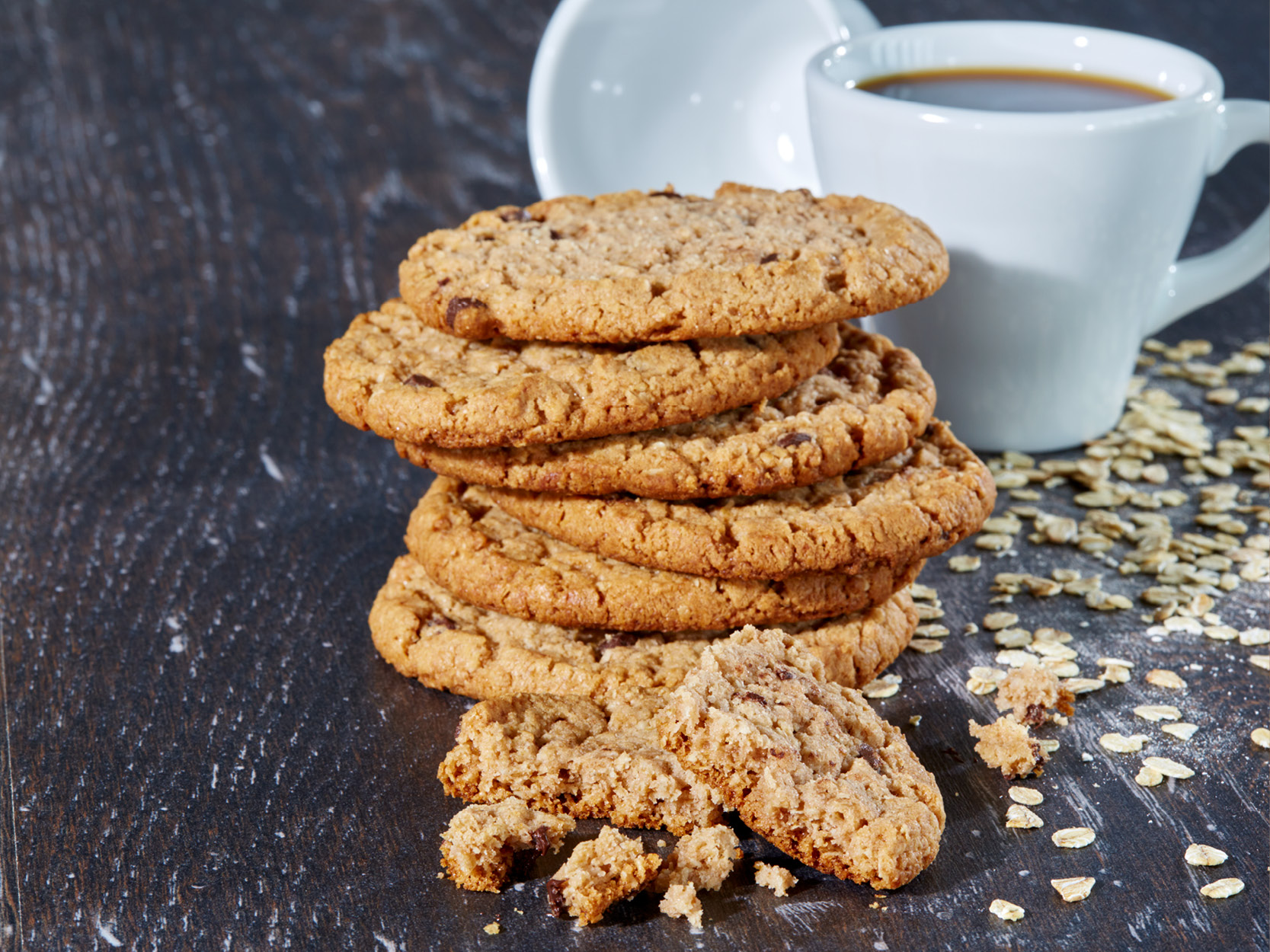Hafercookies, sechs Stück aufeinander gestapelt, einer liegt zerbröselt davor.