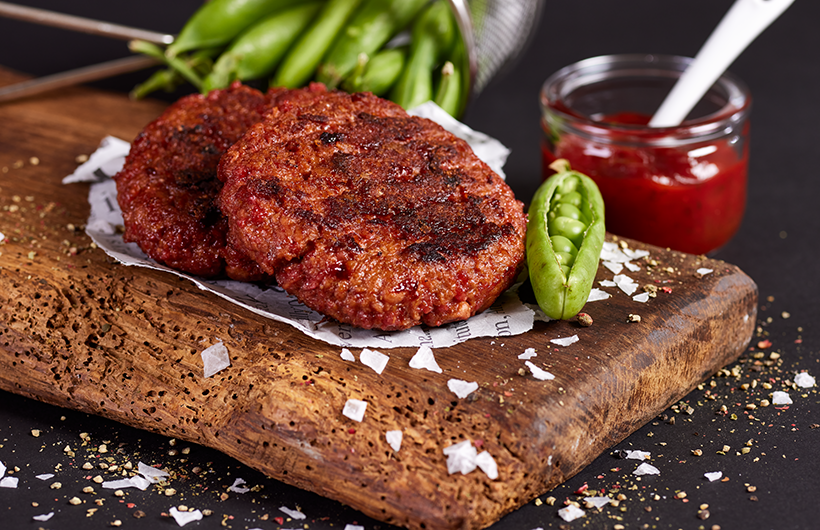gebratener veganer Patty auf Holzbrett