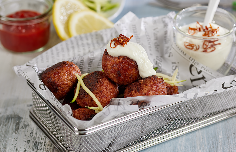 vegane Köttbullar, serviert in kleinem Drahtkörbchen mit Frischkäse-Dip